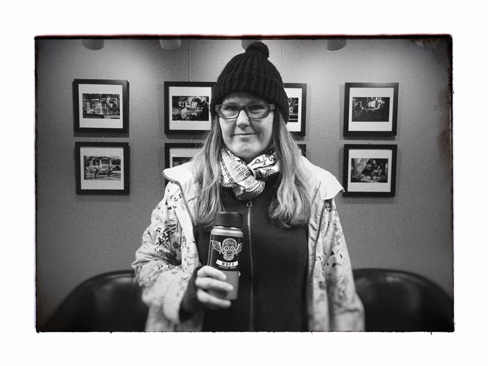 Portland Photo Producer Therese standing in front of her photography exhibit at Pro Photo Supply