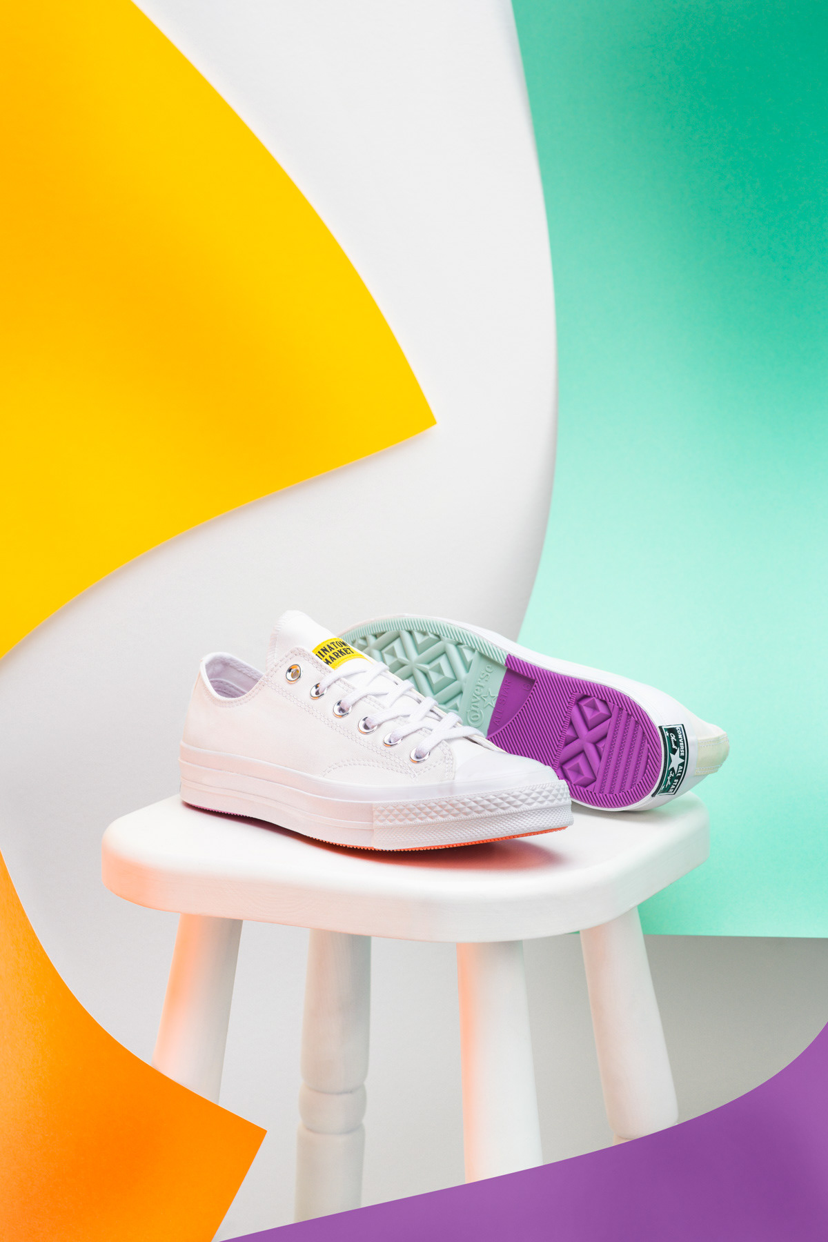Schuhe auf Hocker mit bunten Blättern im Vordergrund und Hintergrund