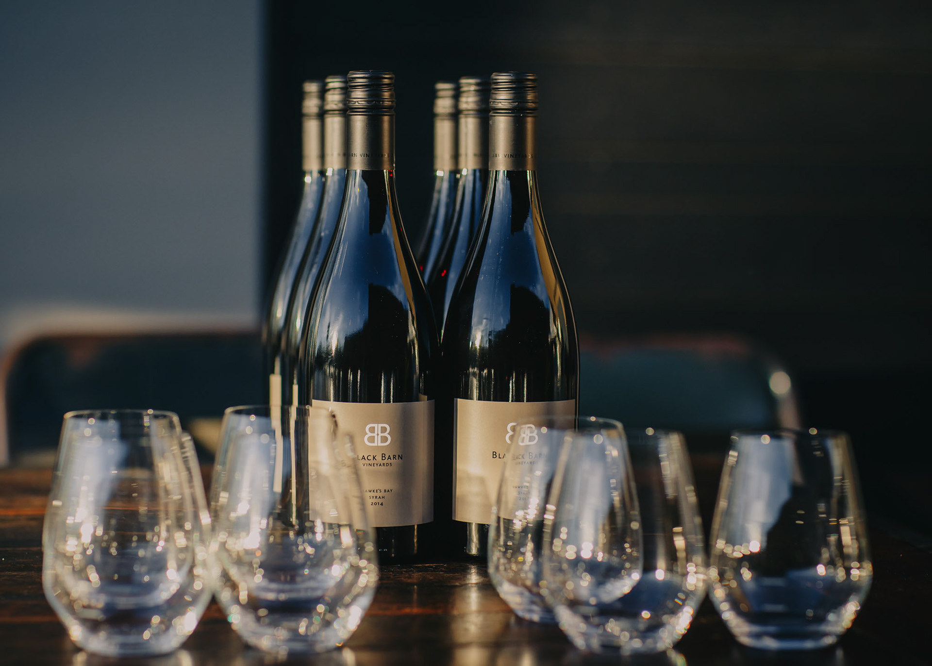Black Barn Vineyards bottles lined up with glasses for guests