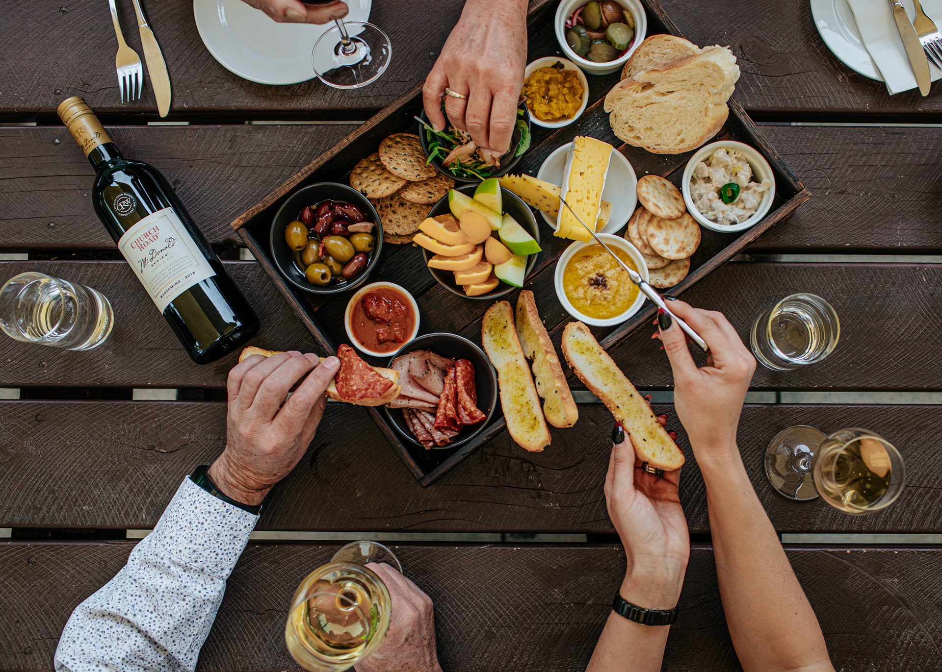 Hands diving into a platter of nibbles at Church Road Winery