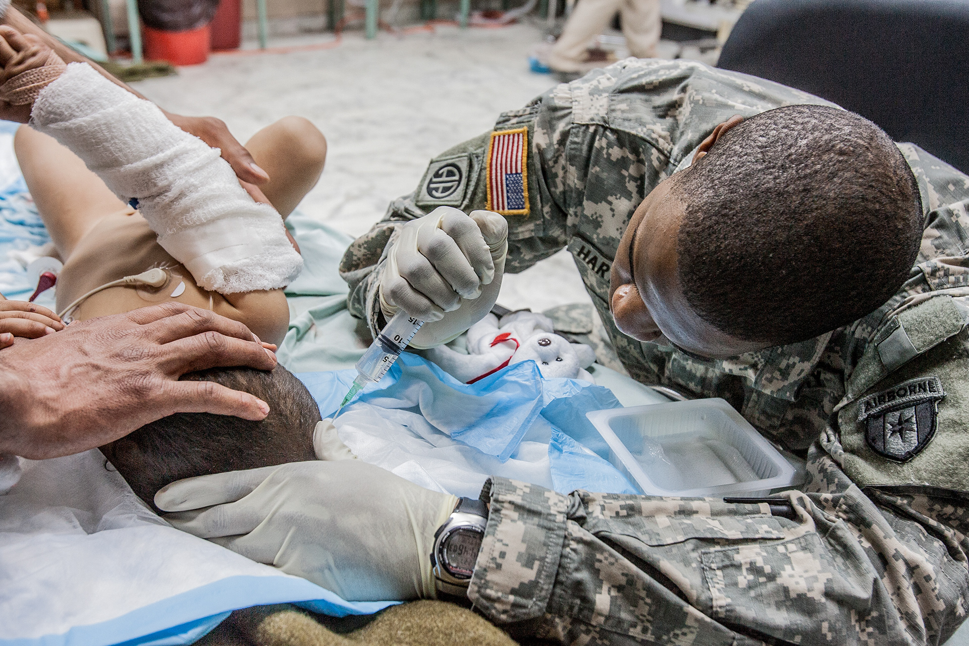 Soldier caring for a 3 year old boy named in one of the trauma rooms at the 28th Combat Support Hospital.