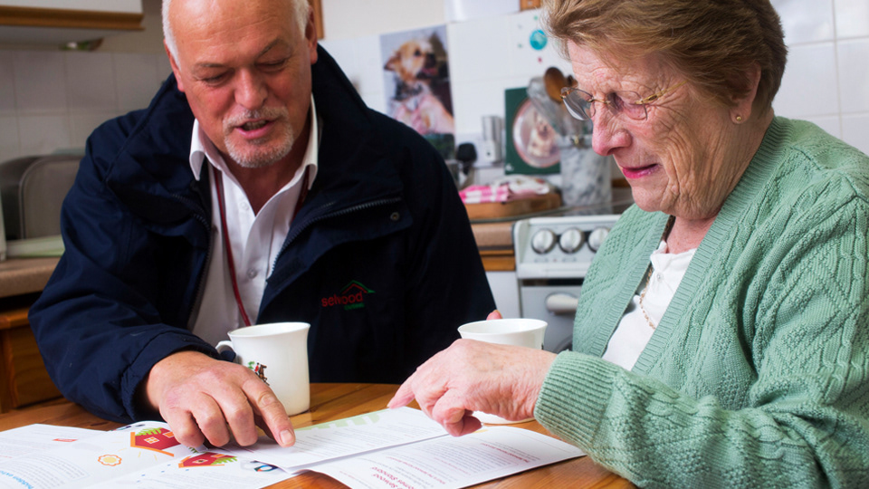 A older lady reading a Selwood Housing brochure