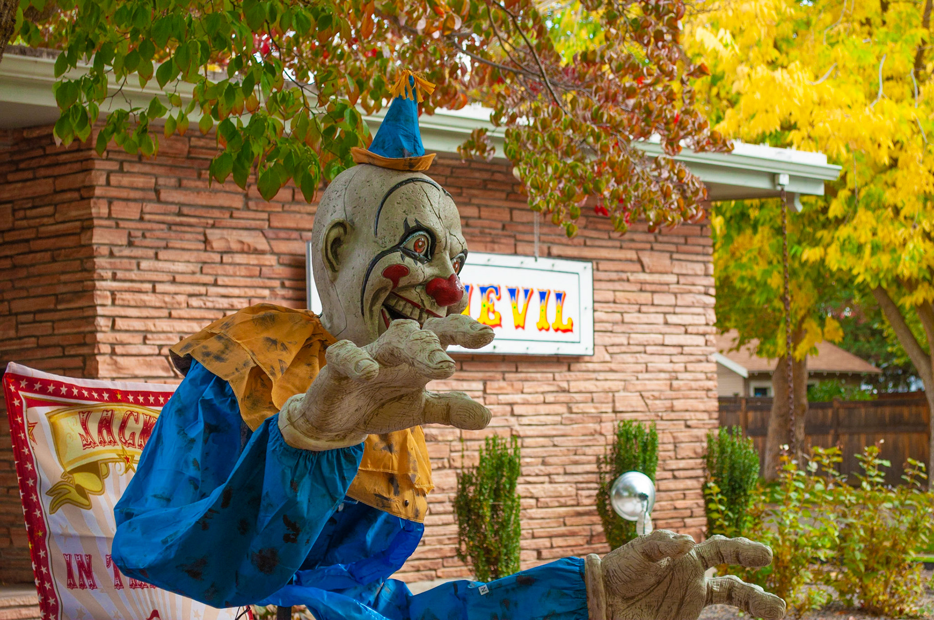 Evil Clown: Evil looking Halloween clown, positioned the shot to highlight the 'evil' behind the clown, 20201011, Harrison Blvd, MILLER, I enjoy this time of year and this particular street very much and capturing the colors and the 'scary' in this shot was fun. Camera Settings: Nikon D5000 ISO 200, 55mm f/8, 1/200s