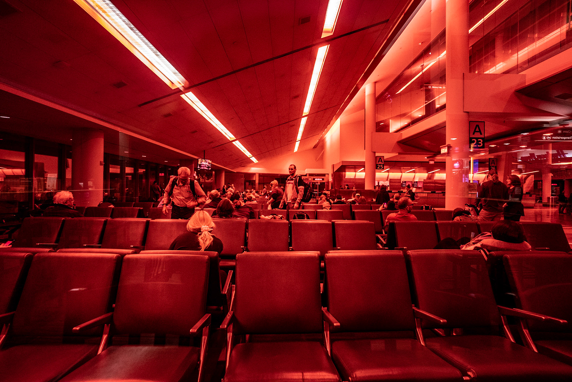 After sitting on the plane on the runway for nearly 3 hours, we were 'deplaned'. Lots of annoyed passengers sitting around. I took this shot through some red glass at the end of a bar.