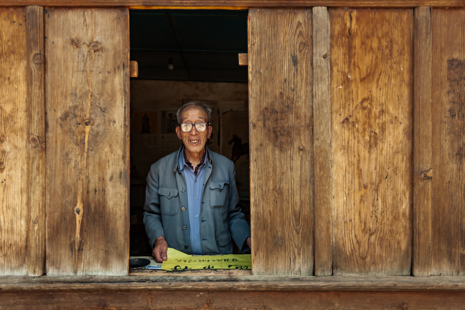 A Chinese Calligrapher making signs using traditional calligraphy in his shop in Shaxi, Yunnan Province, China.