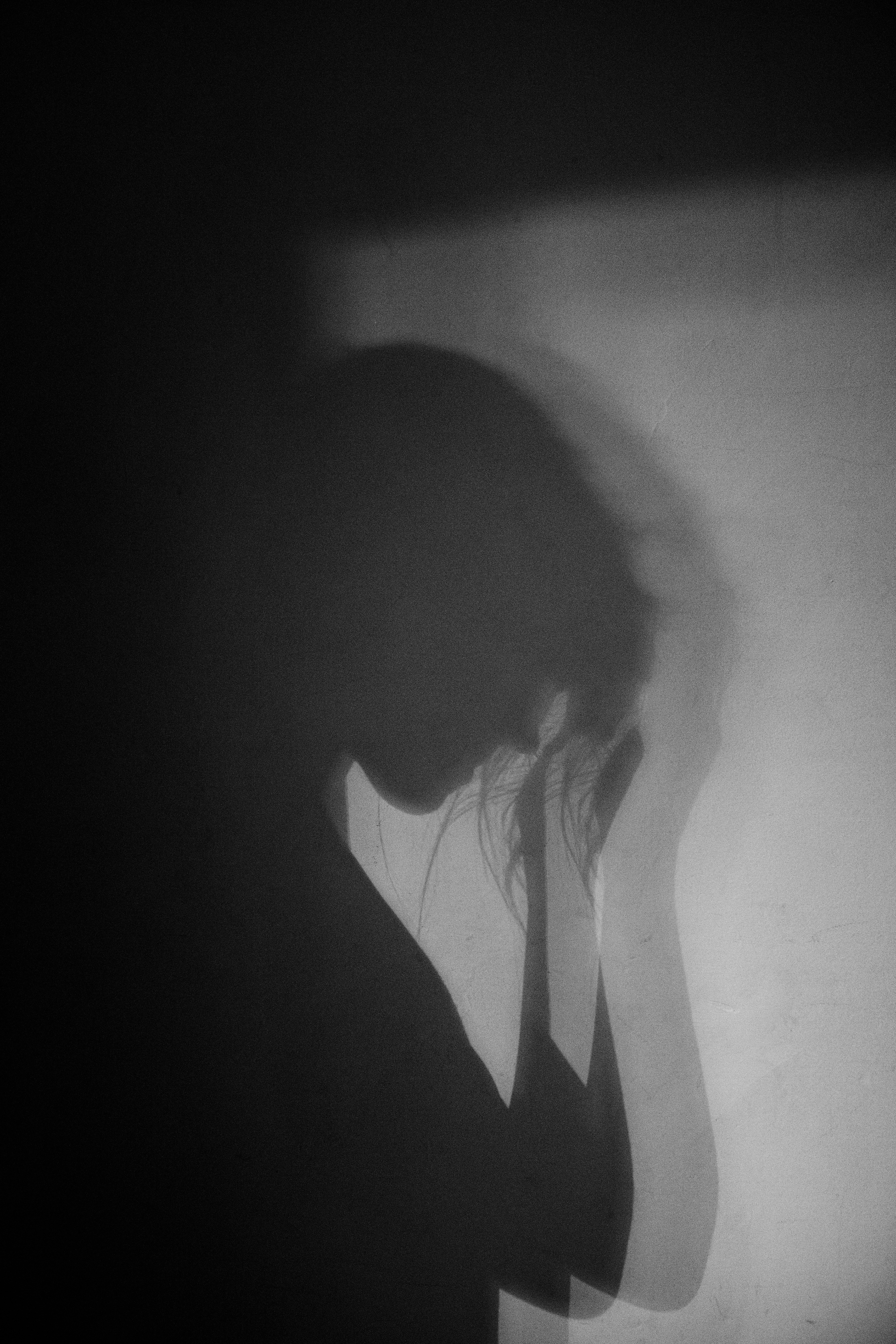 Shadow of a person holding their face in stress or sadness
