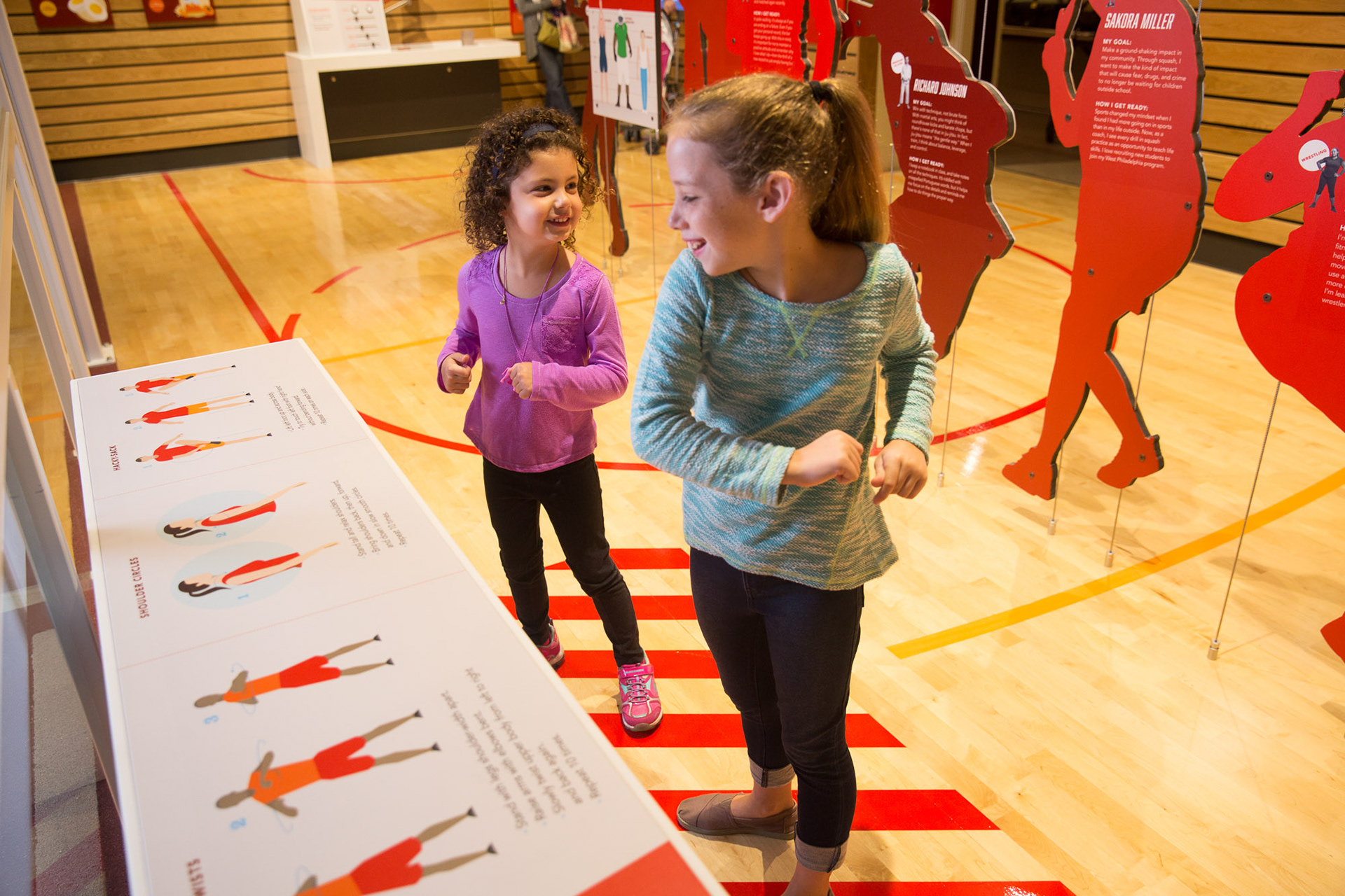 Image of two girls stretching at the stretching station.