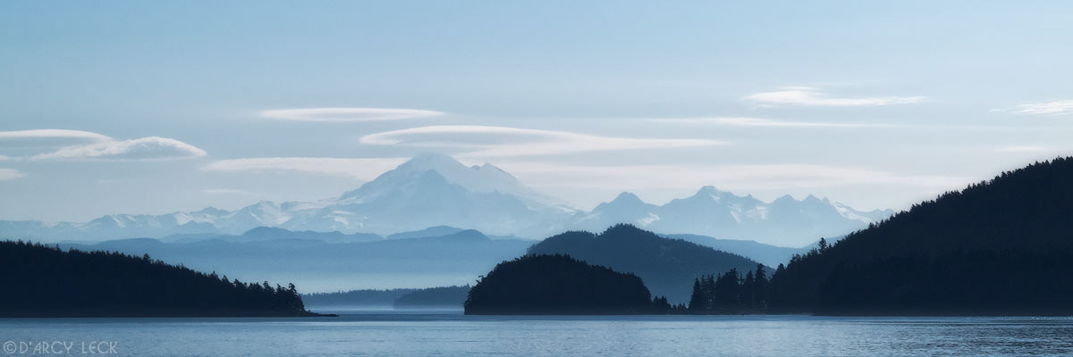 Morning light silhouettes Mount Baker and coastal hills near the San Juan Islands, Washington