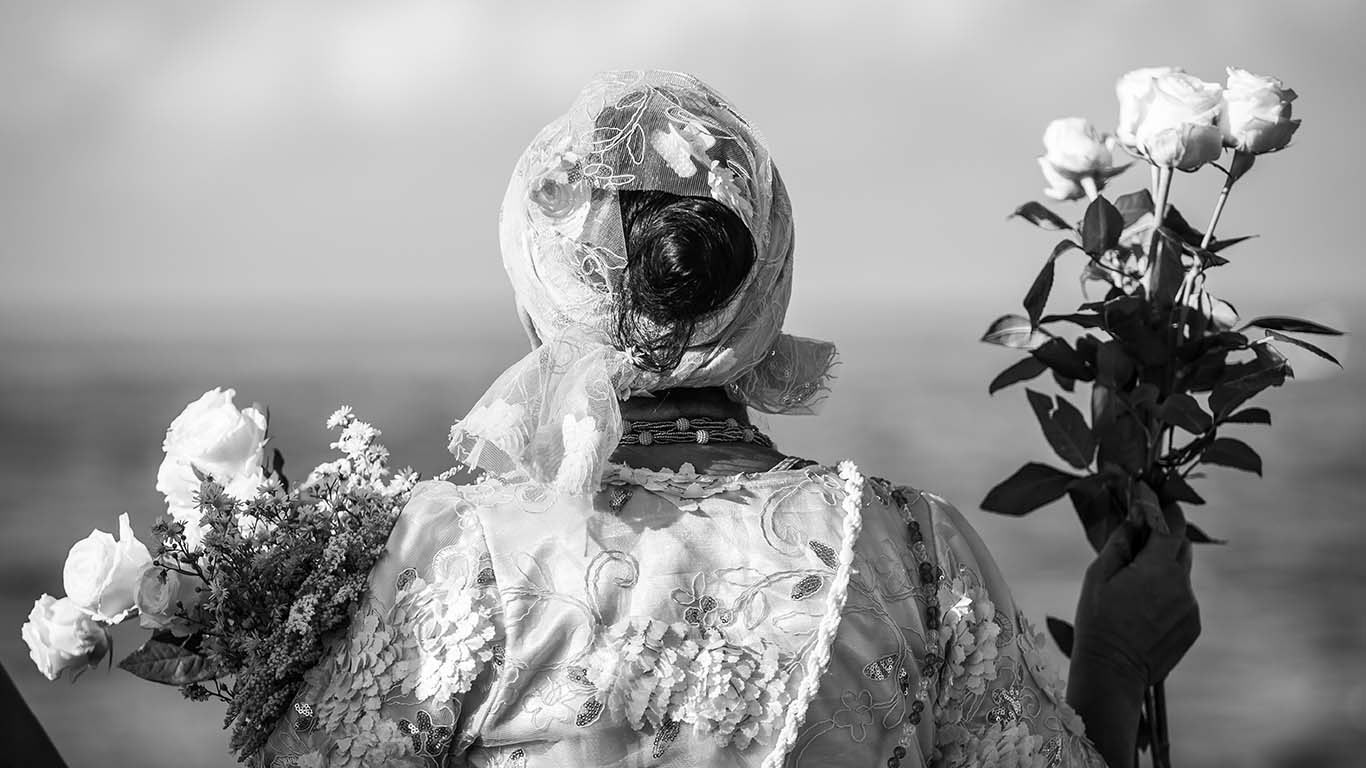 Frau mit Kopftuch und Blumen. Kontaktieren uns Sie: Heinsteinmedia // Rohrbacher Straße 46, 69115 Heidelberg // yh@heinsteinmedia.com // +49(0)6221-3287801