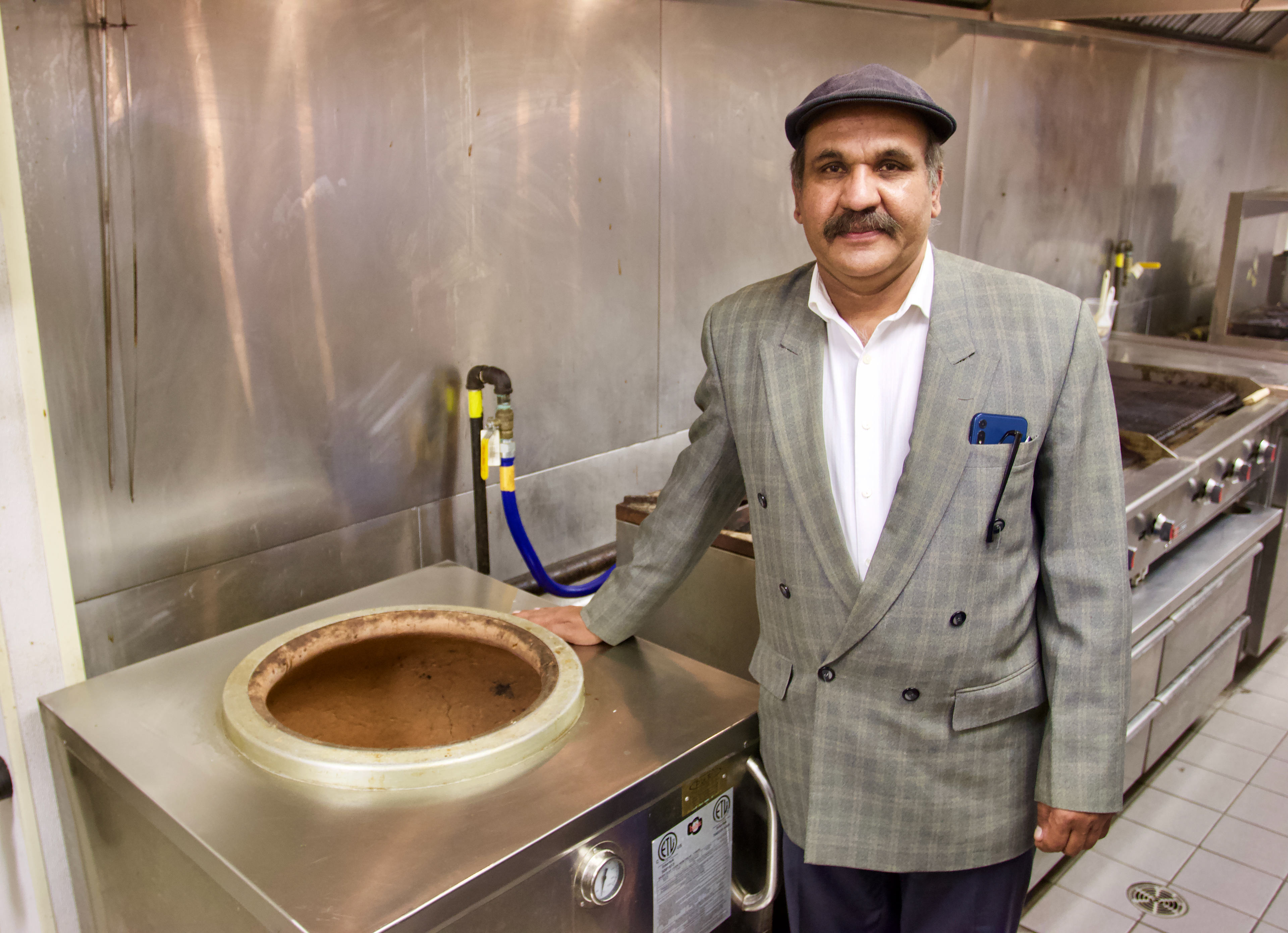 A man stands next to a tandoor at Niagara Tabaq Indian/Pakistani restaurant in Fort Erie at the Flying J Truck stop