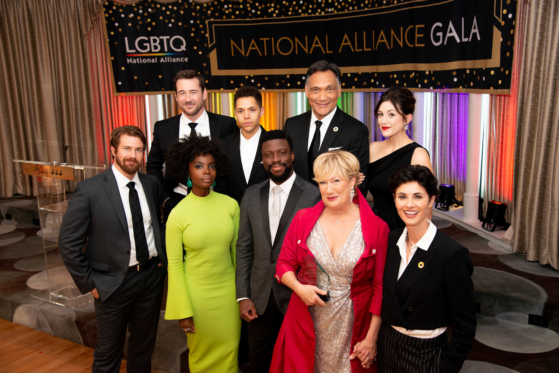 Cast of Bluff City Law in front of LGBTQ gala banner