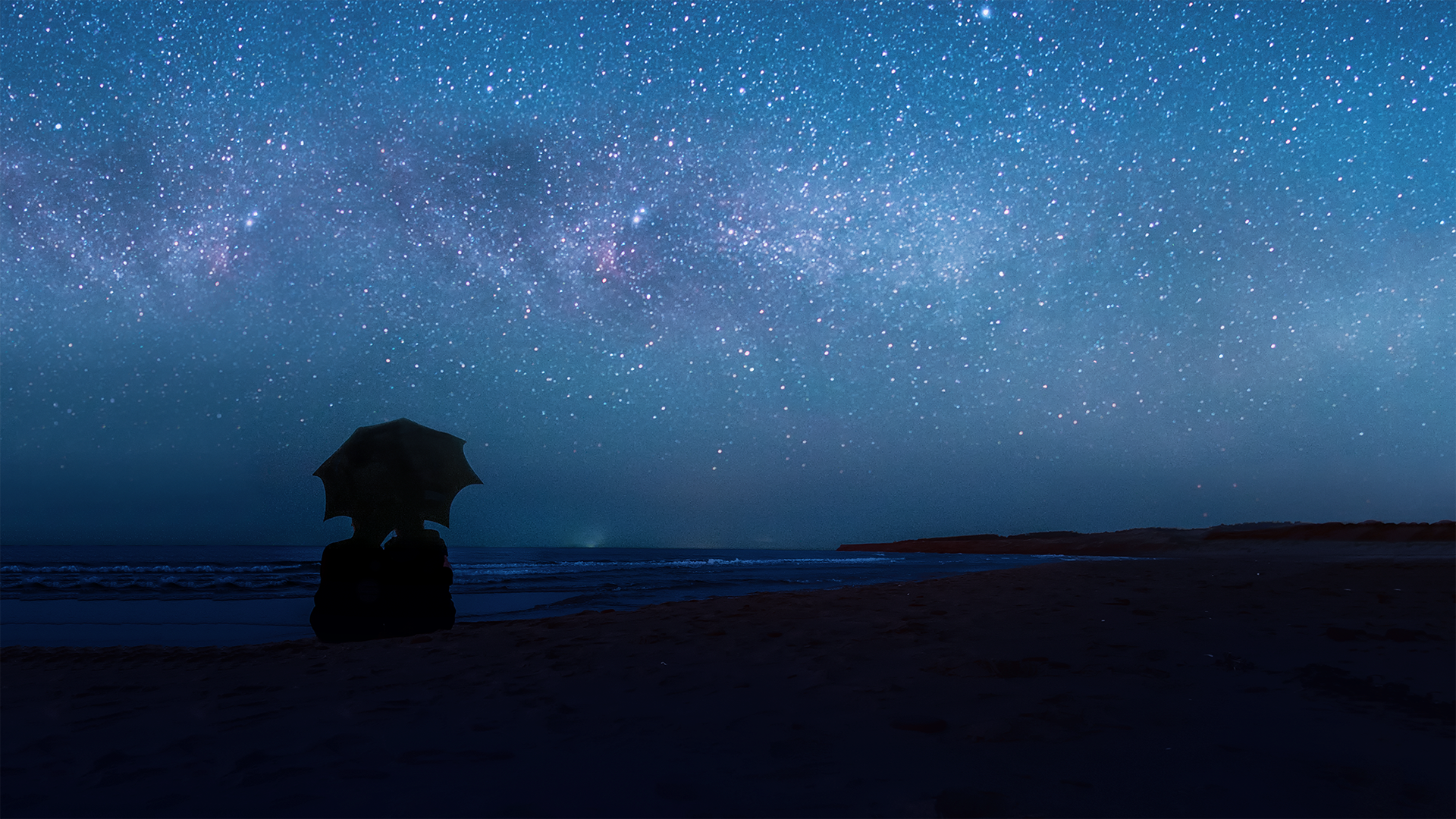 A couple embraces under an umbrella at night while the stars shine vibrantly overhead